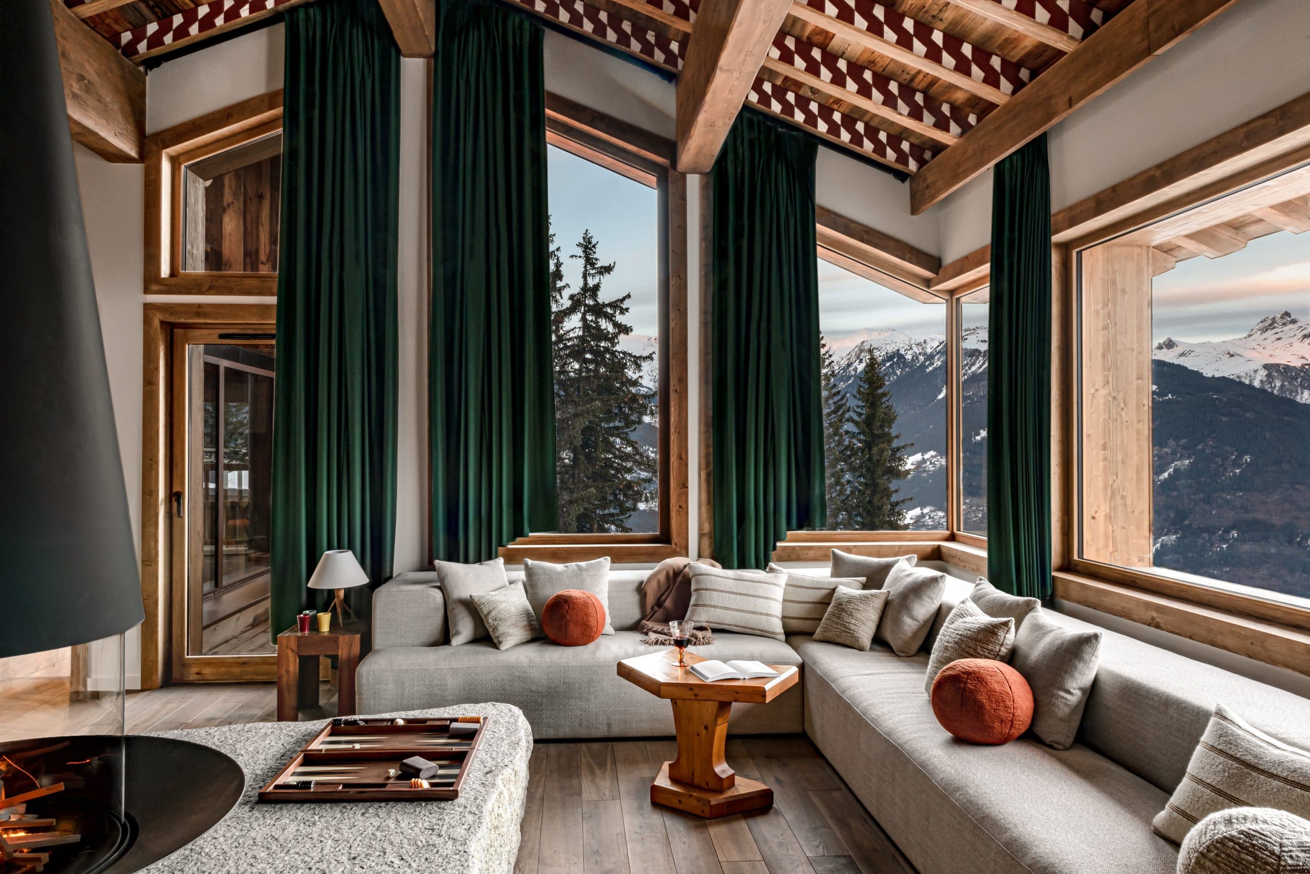 Salon avec chinée, grandes baies vitrées donnant sur la montagne