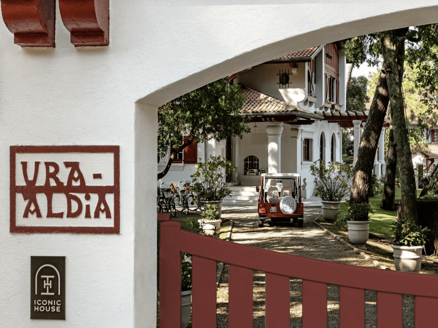 Entrée de la propriété et portail marron, vue lointaine sur la maison aux Bords du Lac