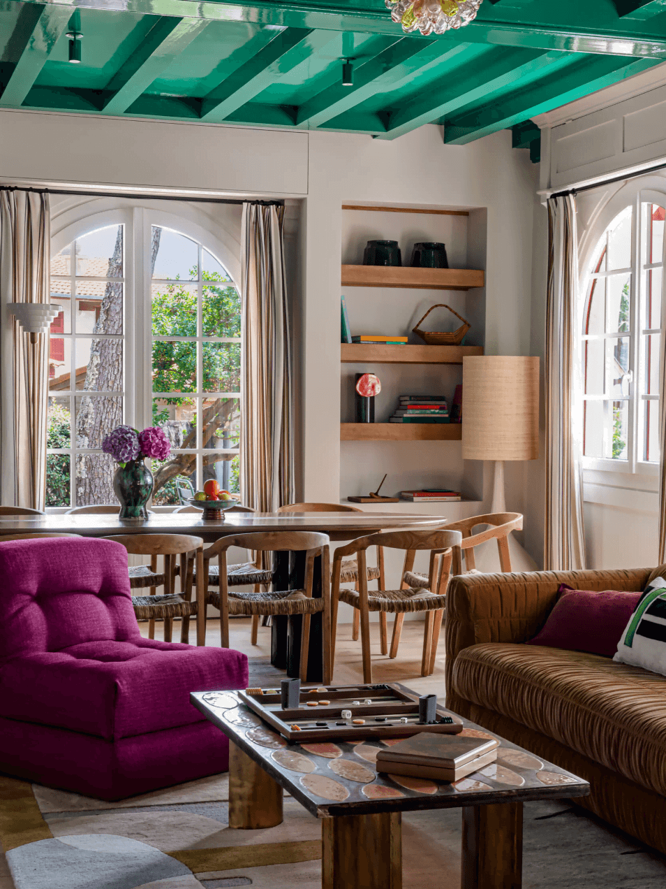 Salon coloré avec table basse, chaise rose et plafond vert aux Bords du Lac