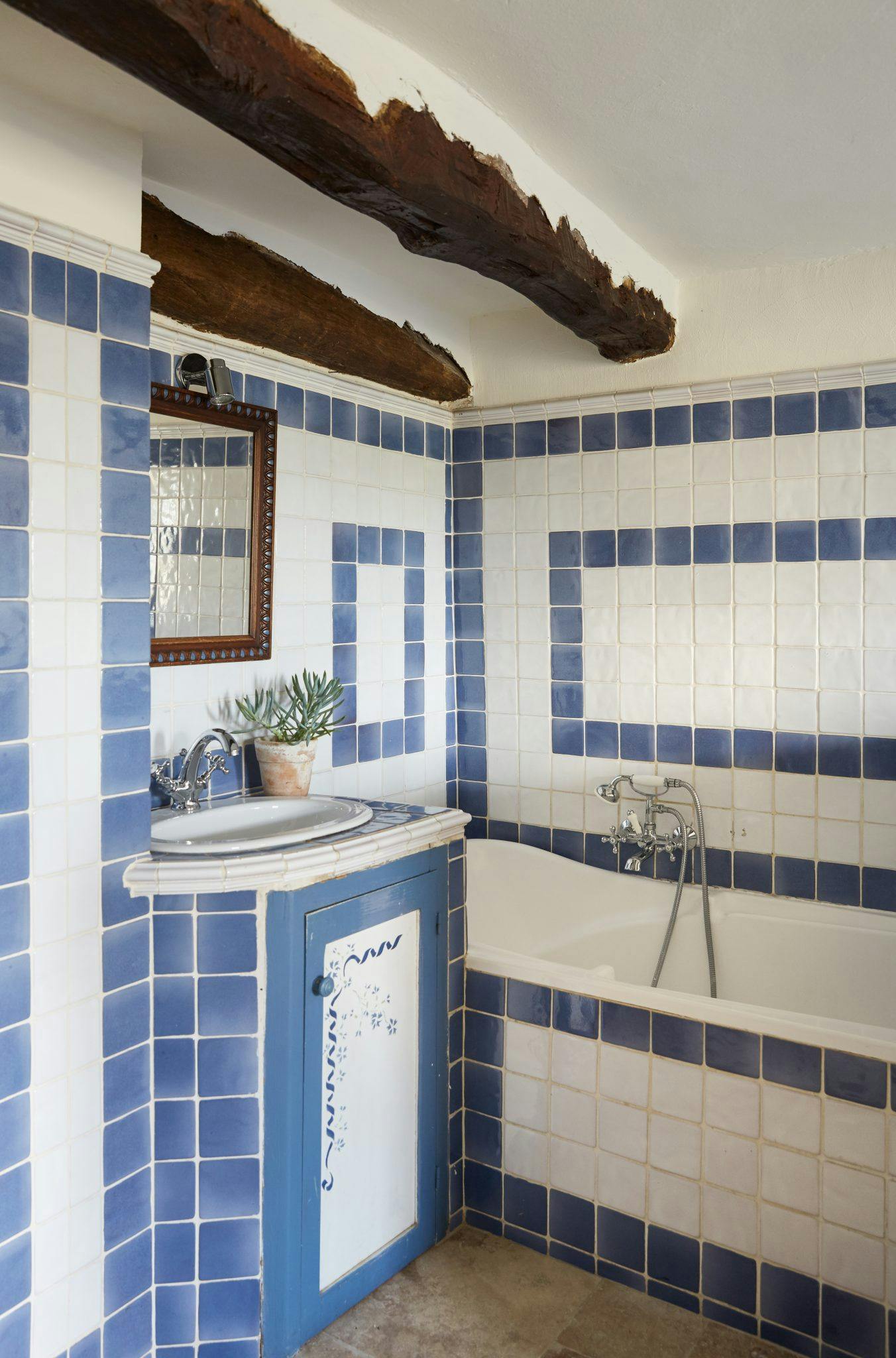 Salle de bain aux carreaux bleus et motifs rectangulaires avec baignoire
