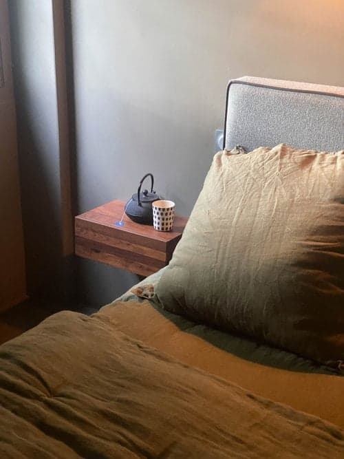 détail de la chambre, coussins et table de nuit