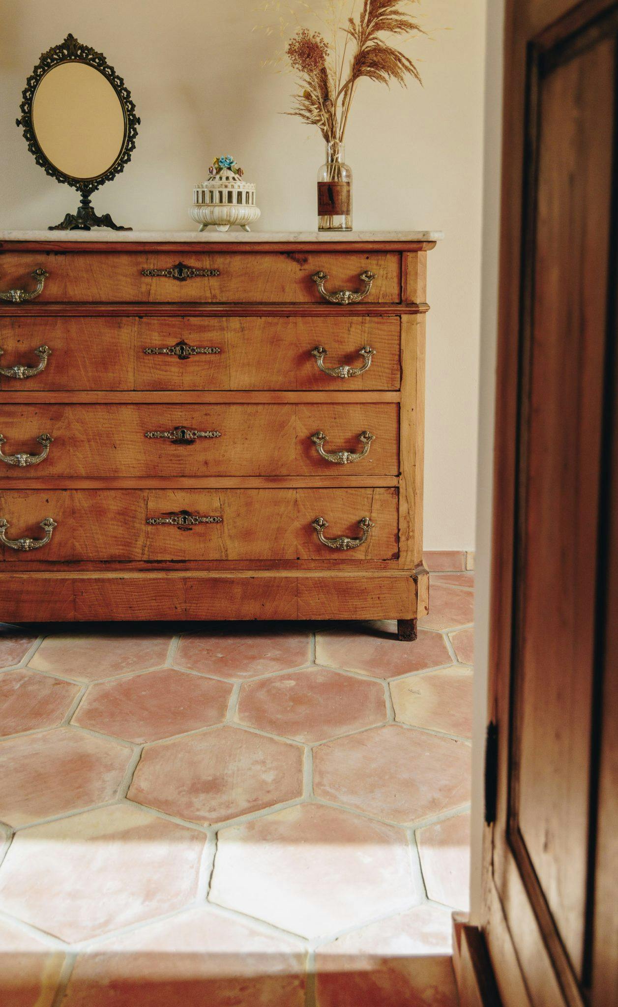 decorated wooden chest of drawers and large tiled floor