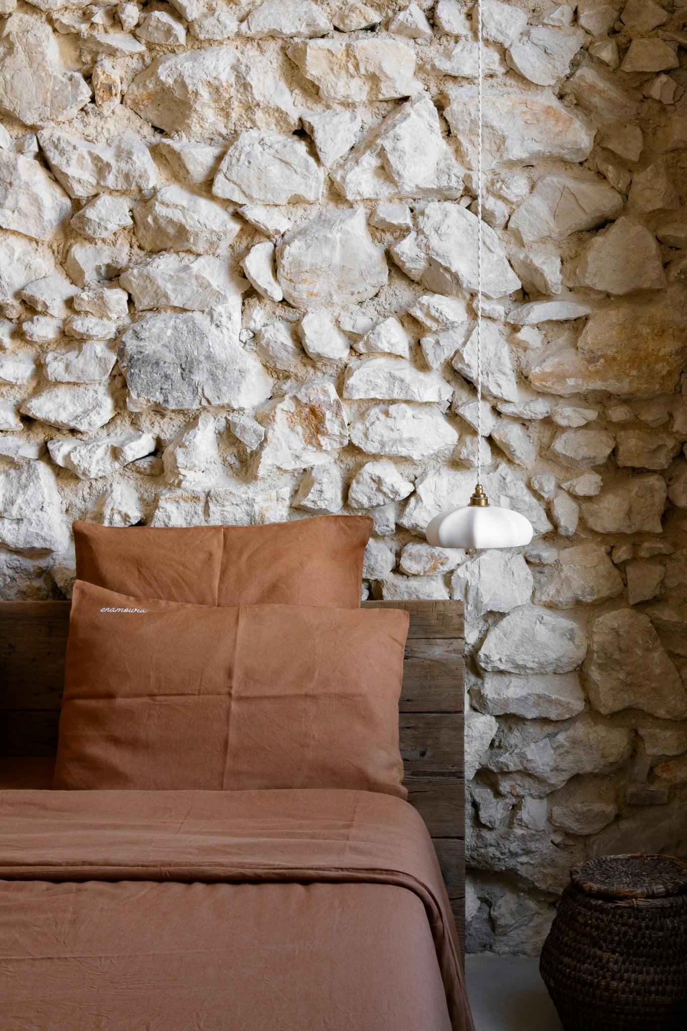 chambre aux tons châtaigne et mur en pierre