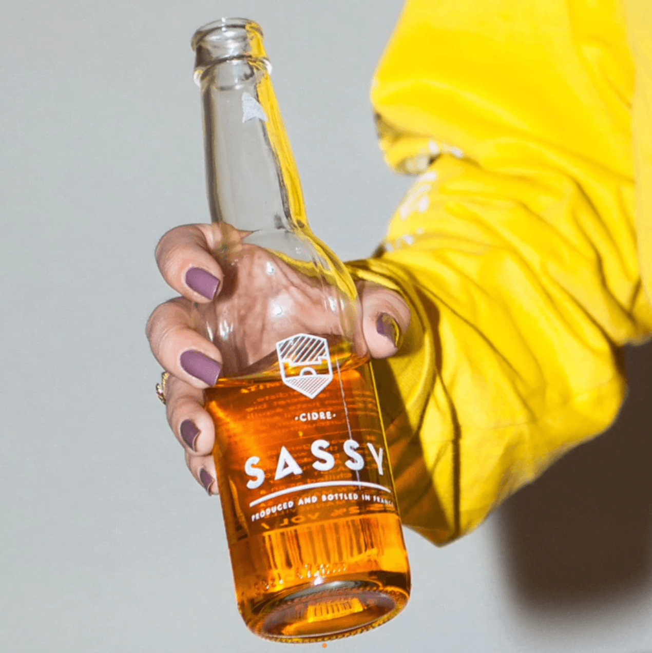 hand-held bottle of cider