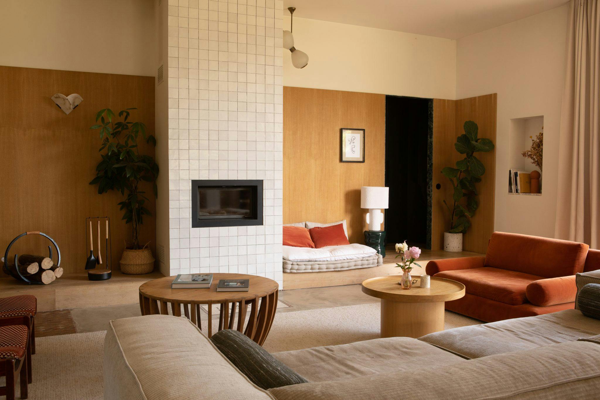 large living room with ochre tones and white tiled fireplace