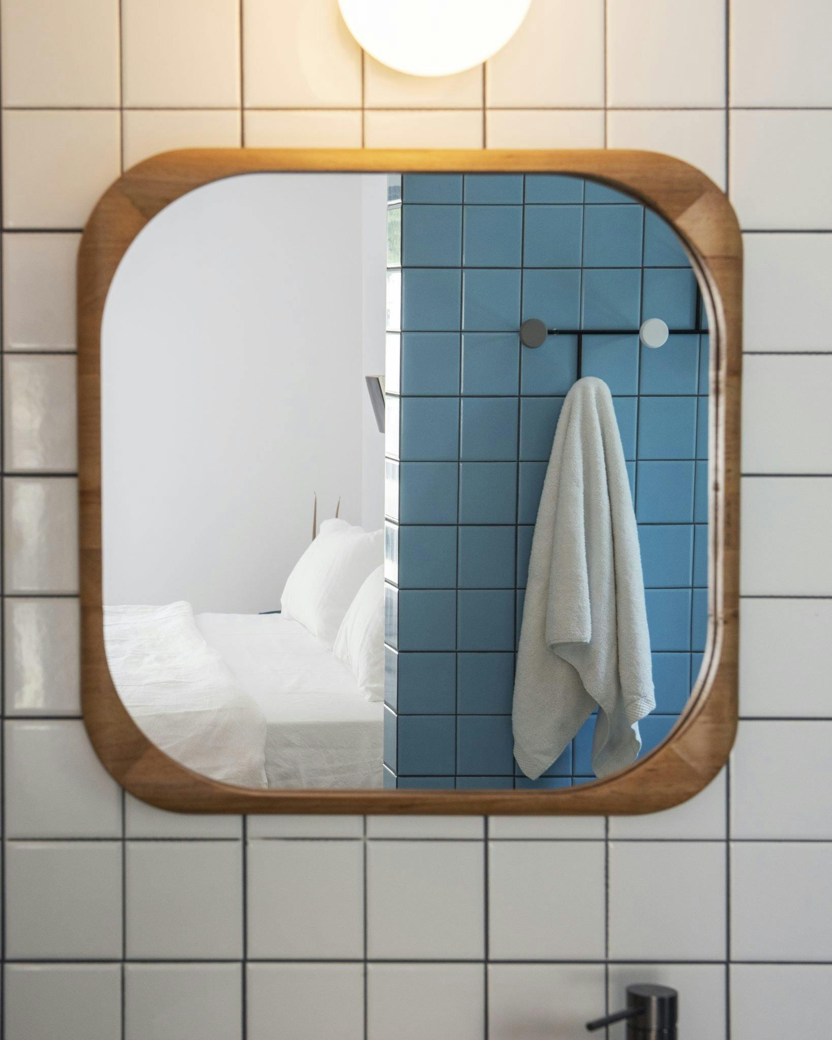 Gros plan sur le miroir de la salle de bain bleue et blanche de l'Atelier des Milles Roches