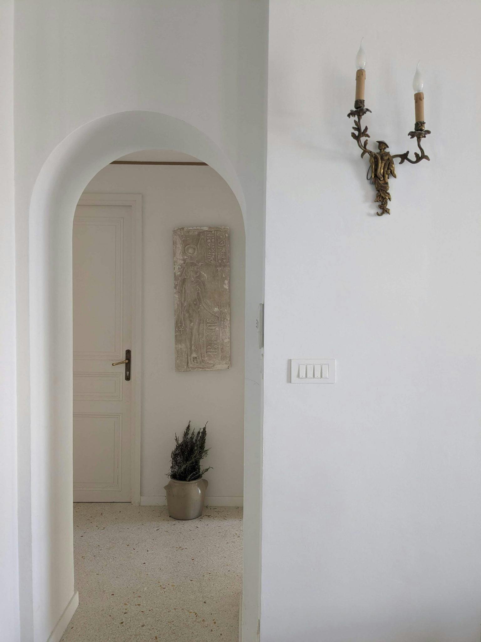 enfilade view of the hallway and alcove, antique wall lighting and terrazzo floor