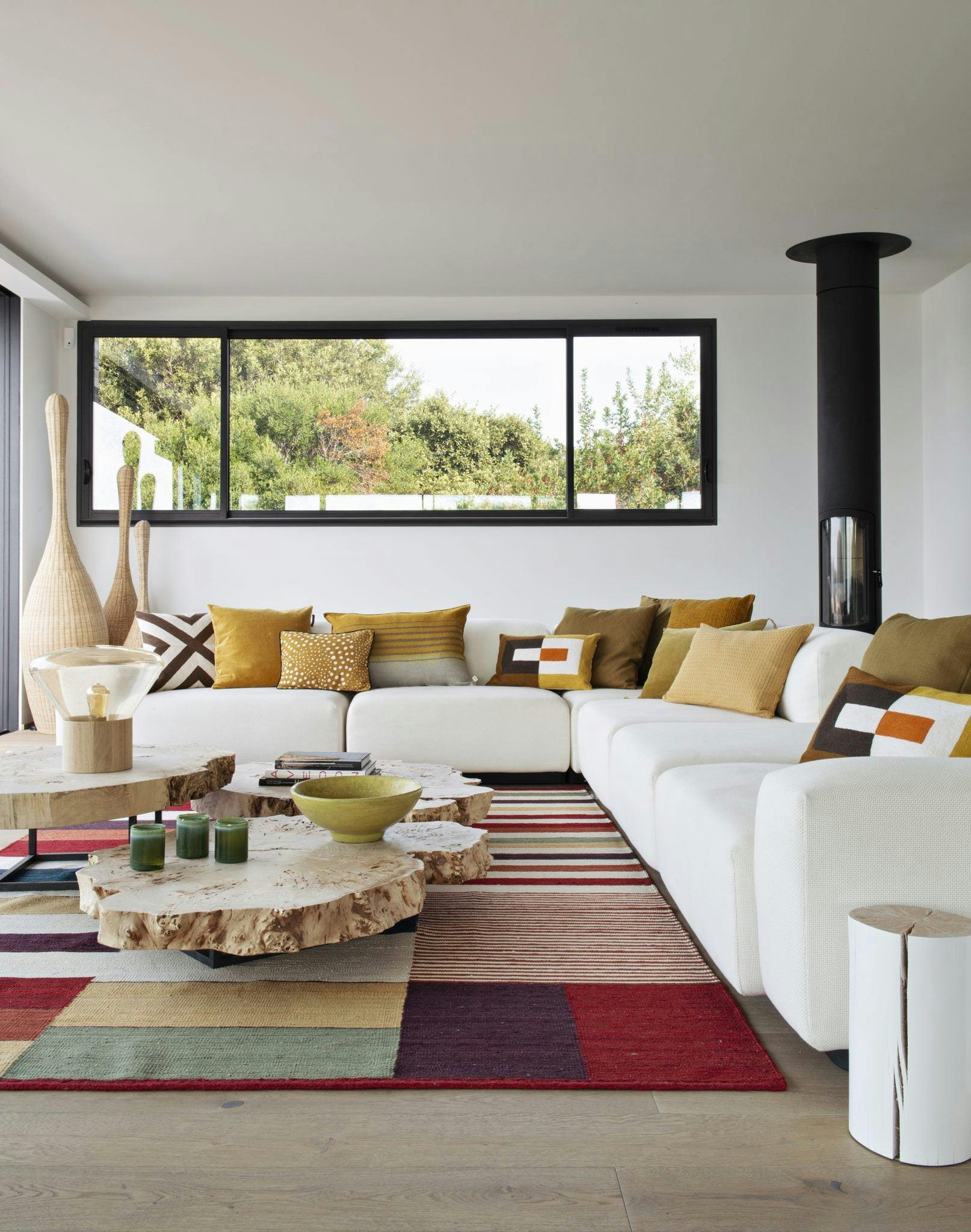 grand salon blanc avec des canapés et un tapis colorés