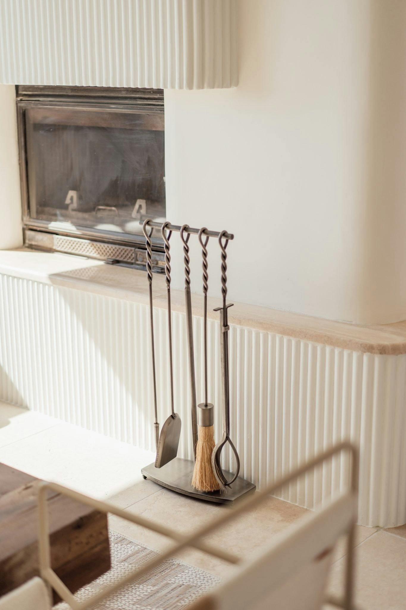 Fireplace tools, with the castrée fireplace in the background