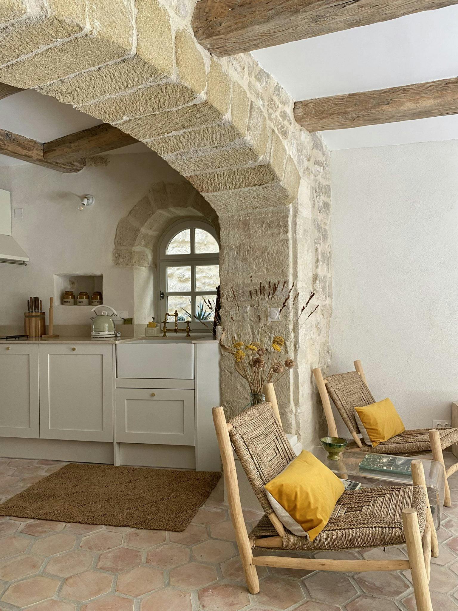 A large stone archway joins the kitchen and living room.