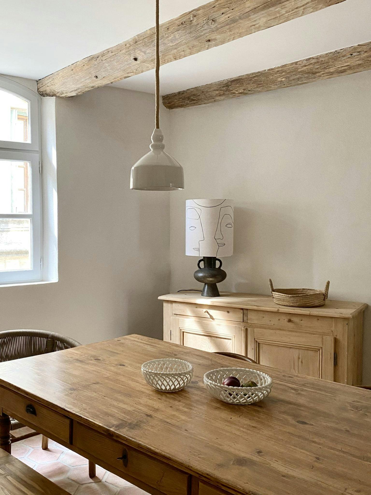 Large farm table in a bright room, sideboard and window