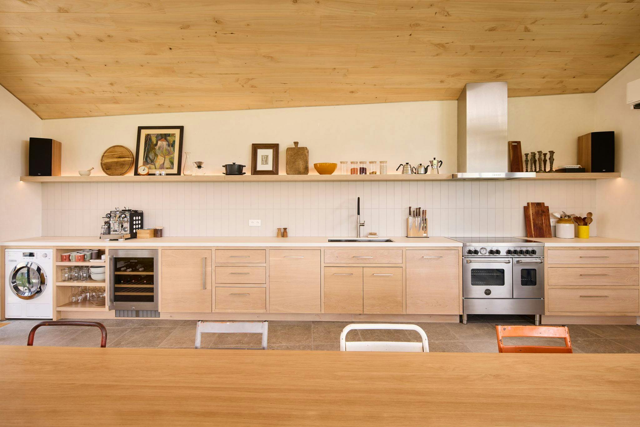 Atelier kitchen, in light, woody tones, across its entire width