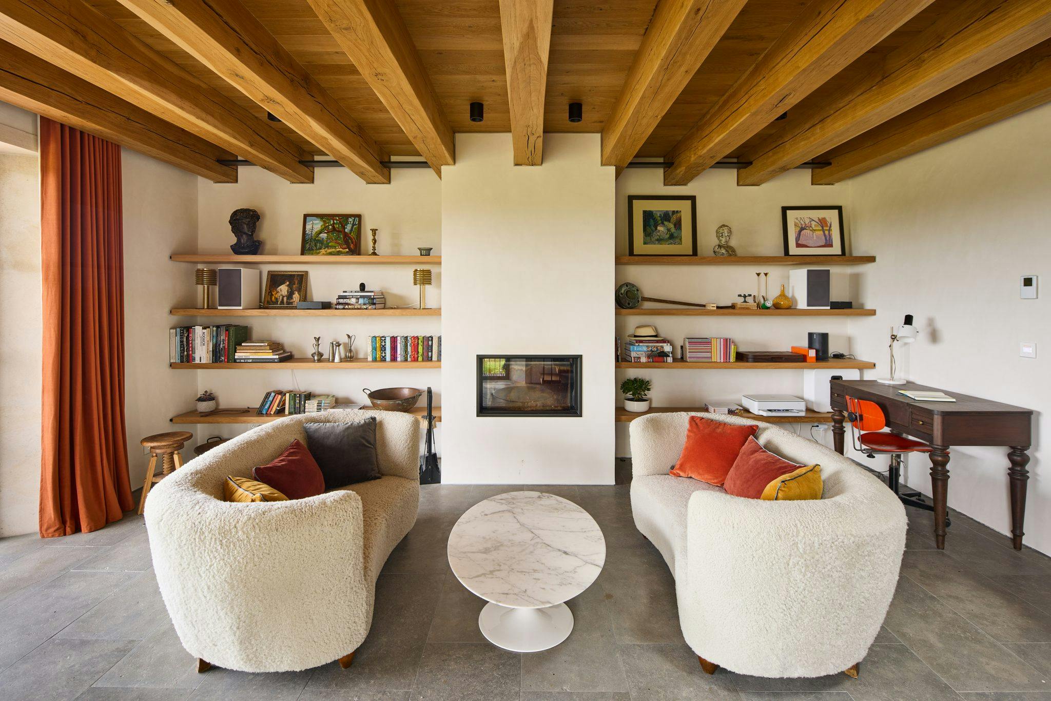 Fireplace-living room, bookcase and two sheep's wool sofas facing each other