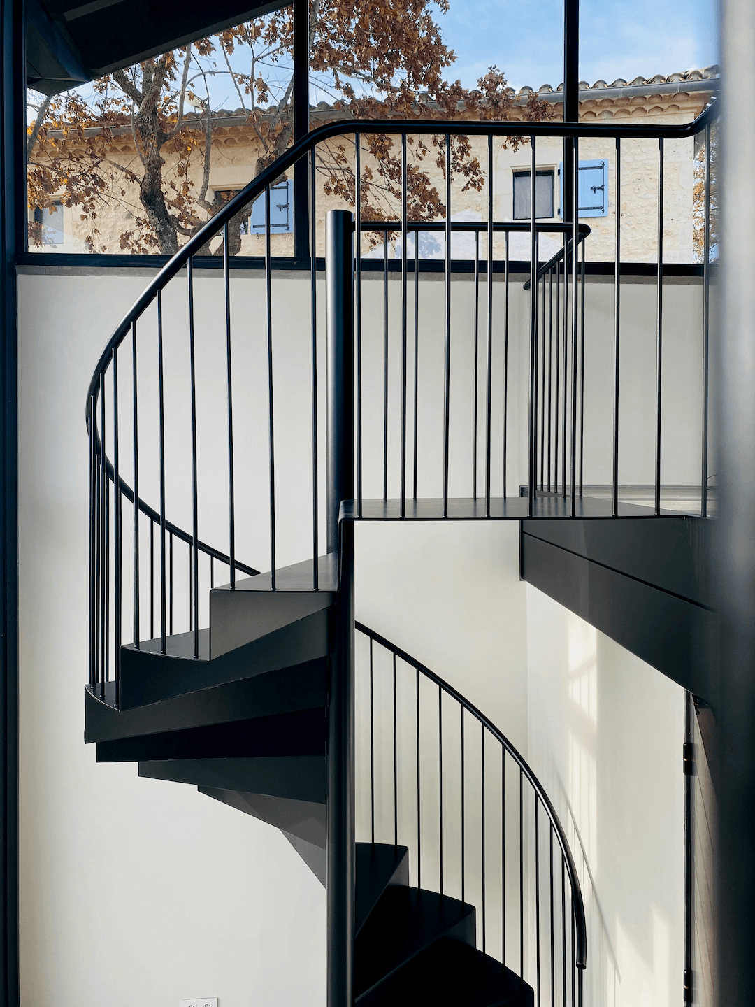 Black spiral staircase on white wall