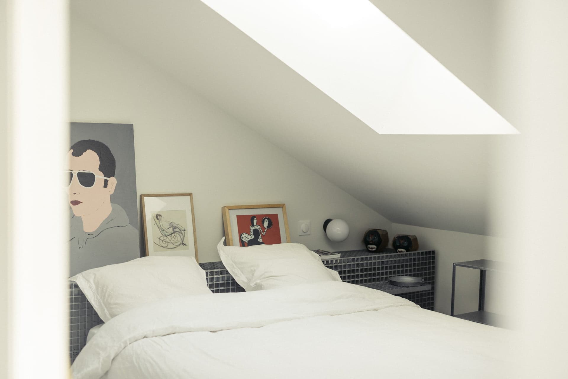 Chambre, lit double sous velux et cadres posés sur la tête de lit