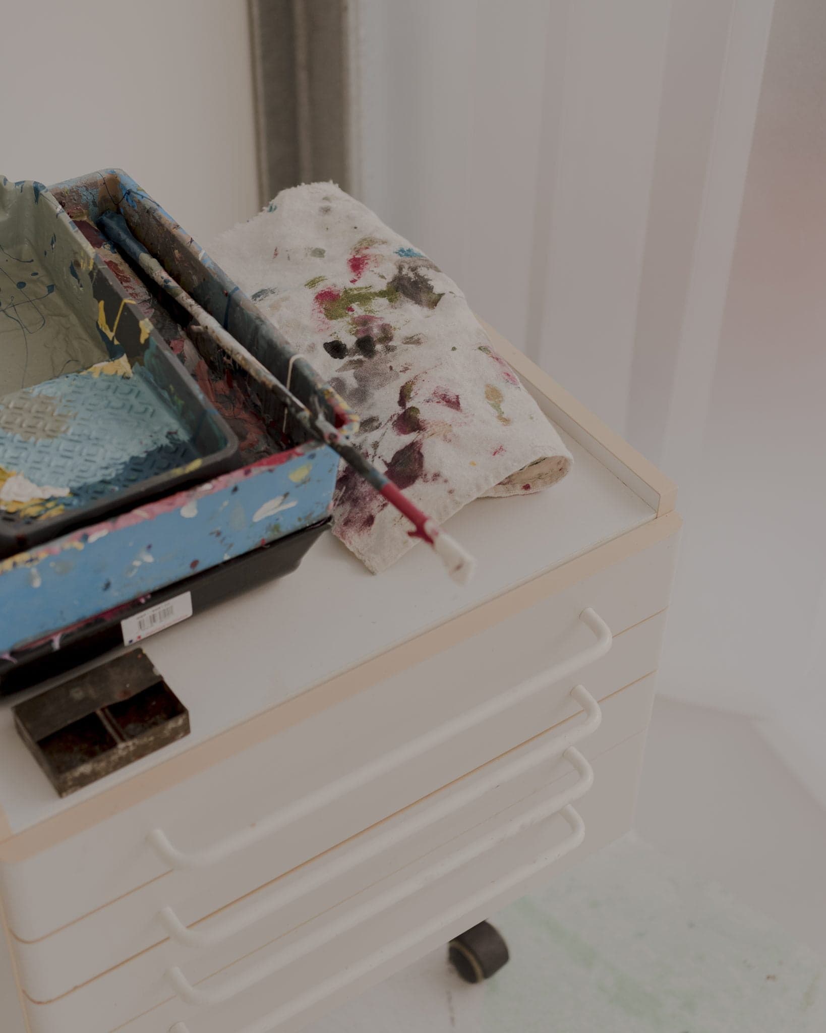 Accessoires de peinture qui reposent sur un meuble bas blanc