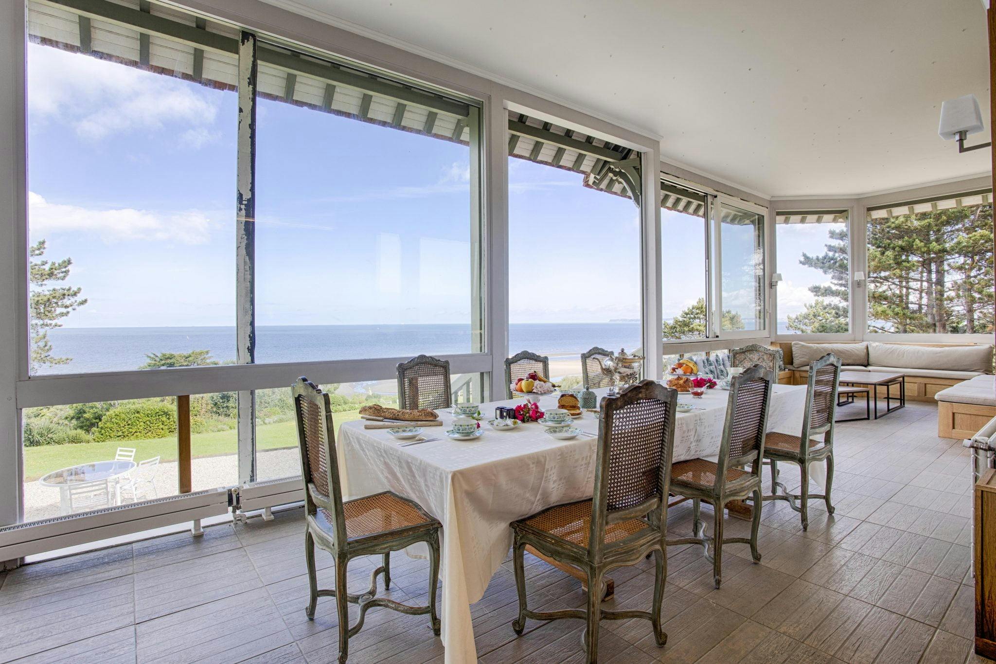 Dining room in front of large bay windows facing the sea