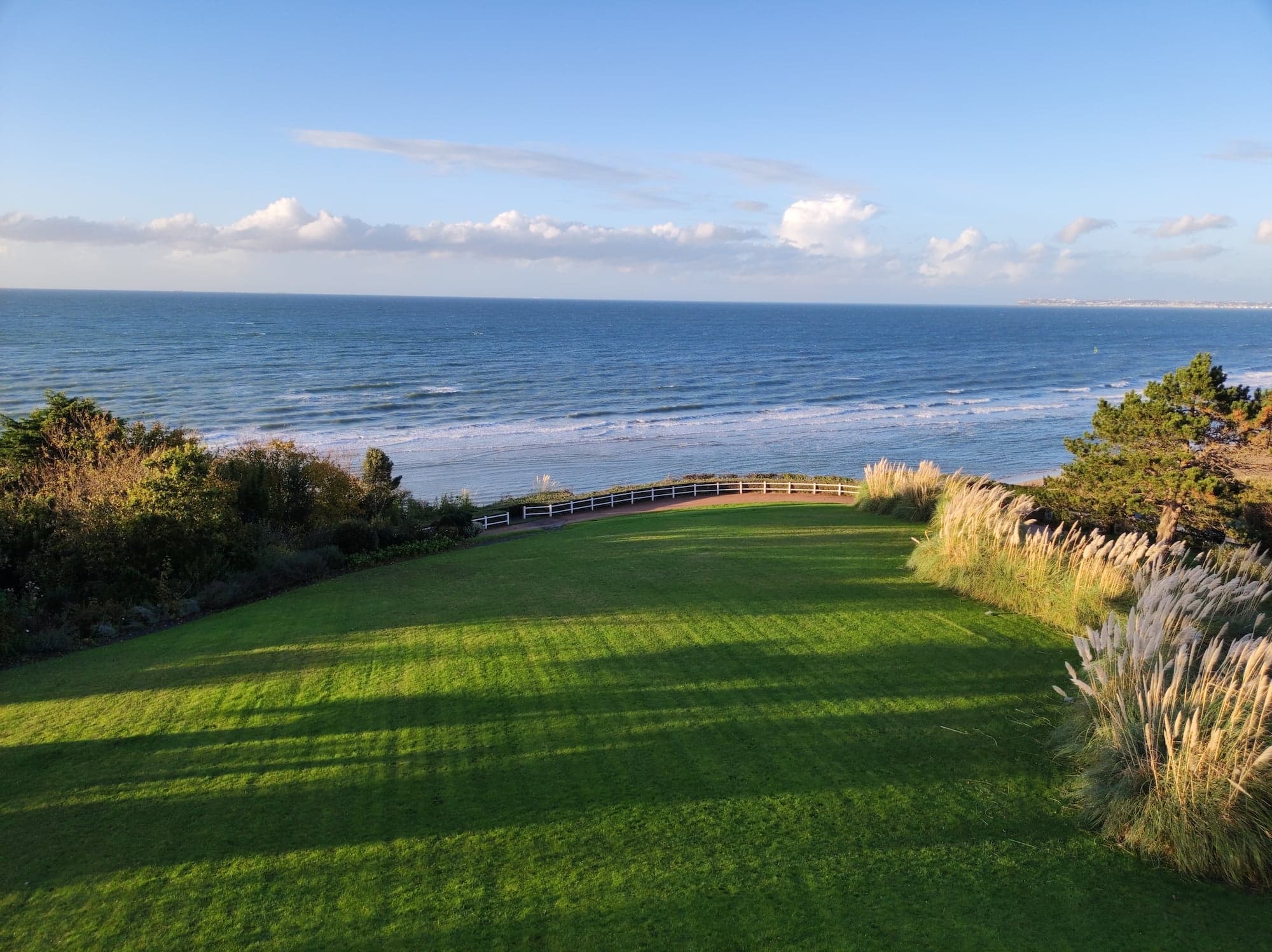 Lawn in front of the sea and the sun's rays