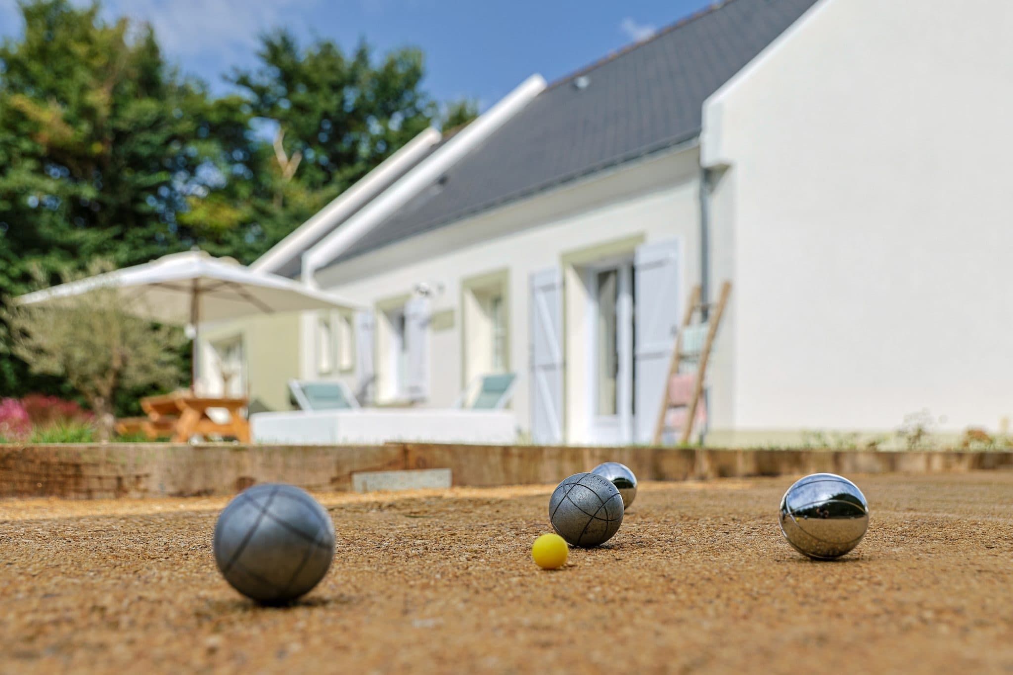 Terrain de pétanque et la maison La Bien Aimée en arrière-plan