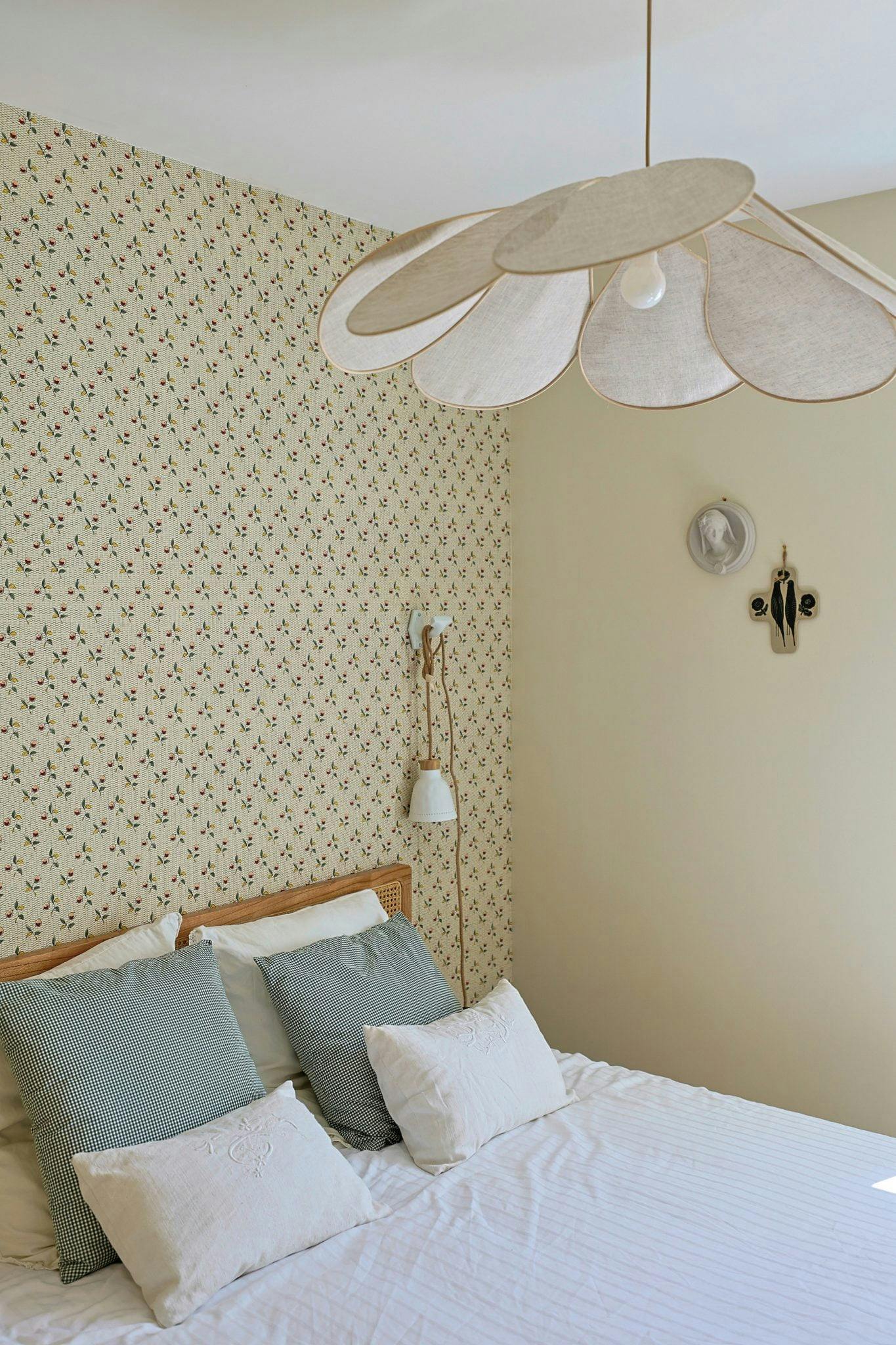 Bed and bedroom walls covered with floral wallpaper