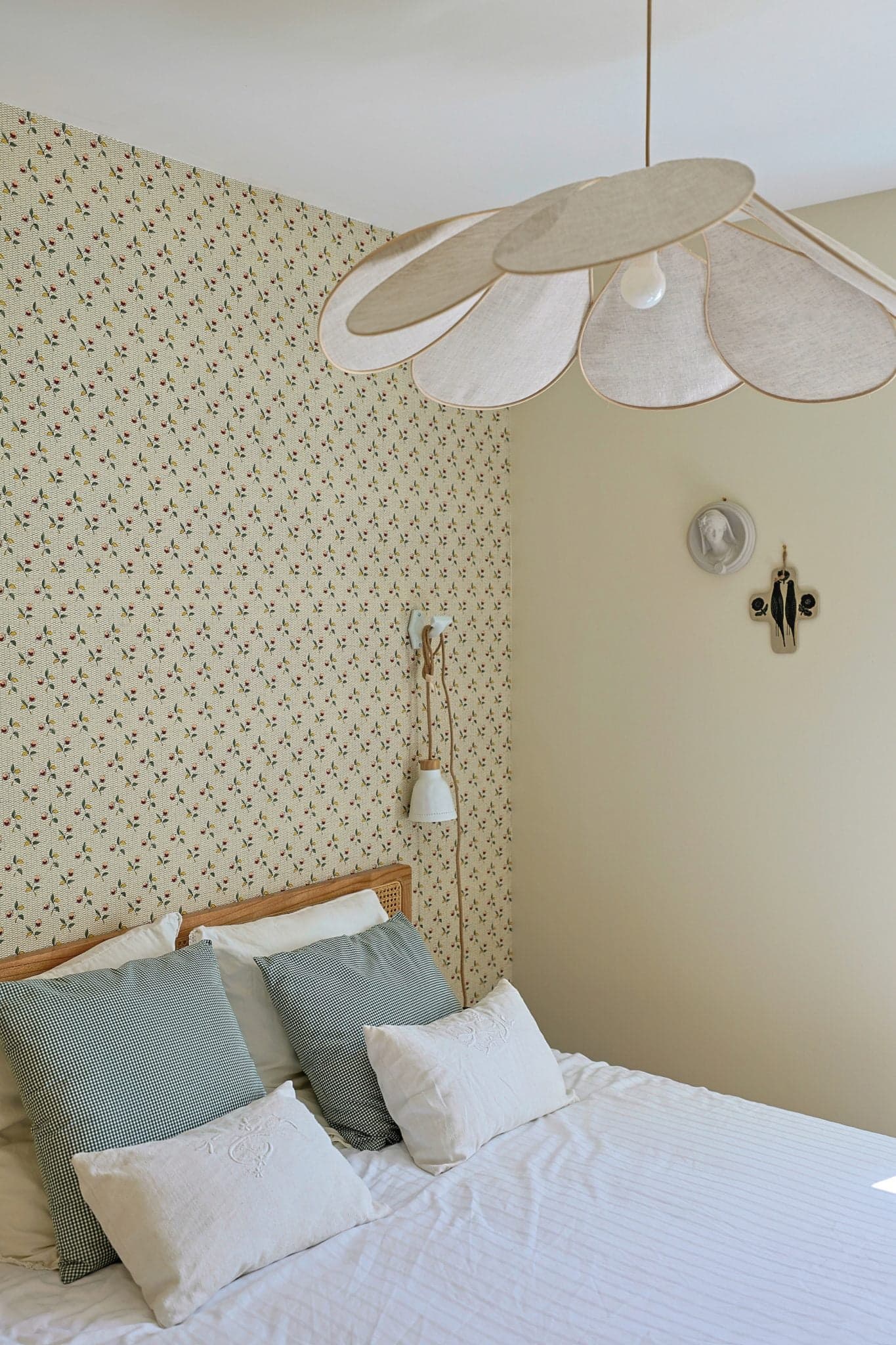 Bed and bedroom walls covered with floral wallpaper