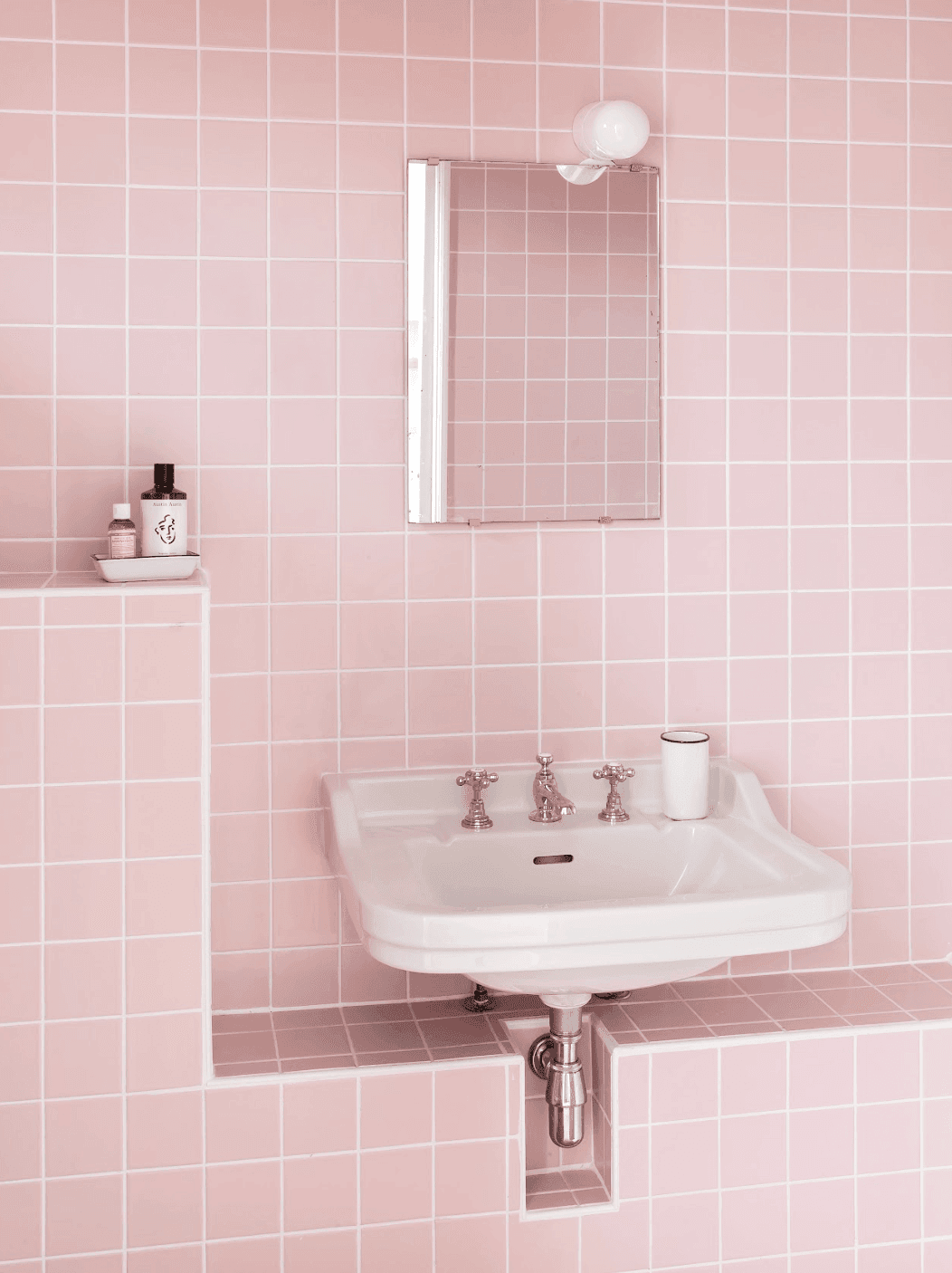Lavabo de la salle de bain, carrelage rose et miroir