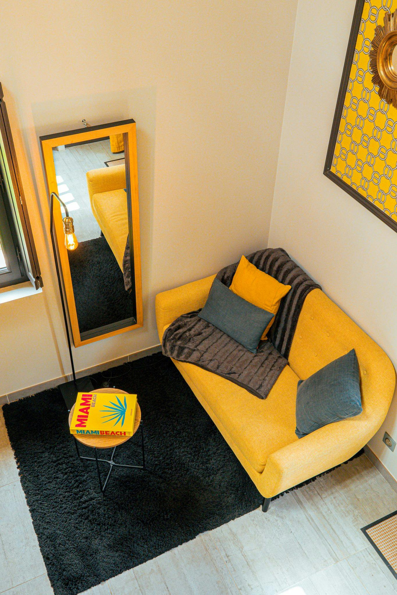 Small modern living room with yellow sofa