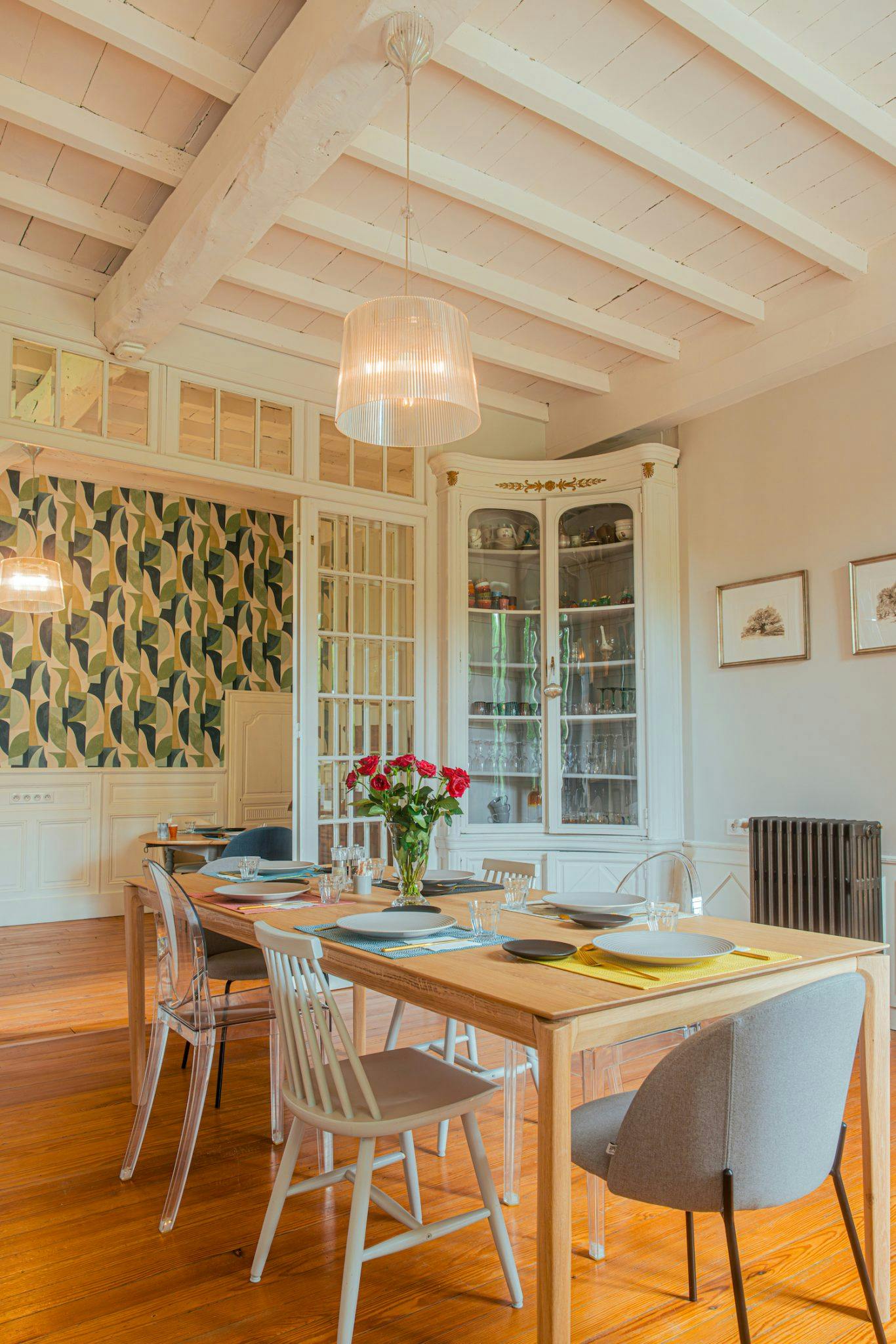 Dining room with high ceilings, 6-person central table and bouquet