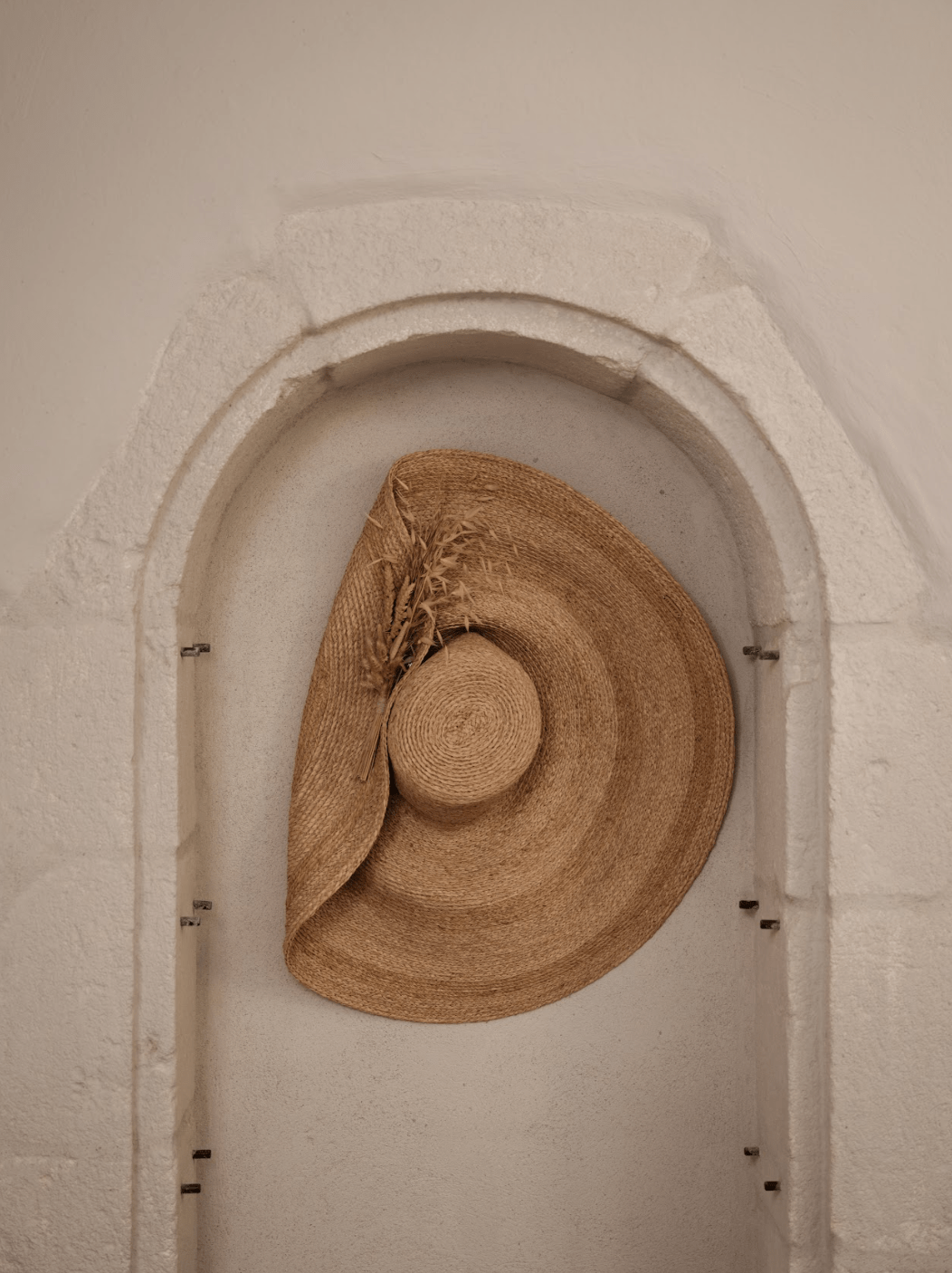 Straw hat hanging on a stone wall at the Maison des Remparts.