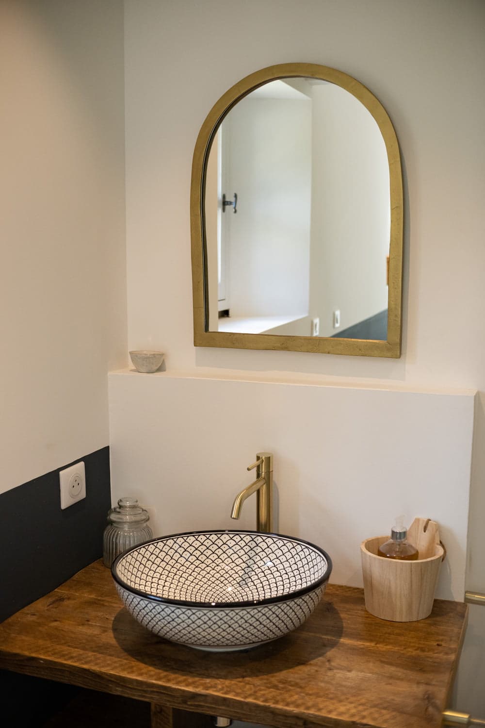 Miroir aux contours dorés et lavabo de la salle de bain