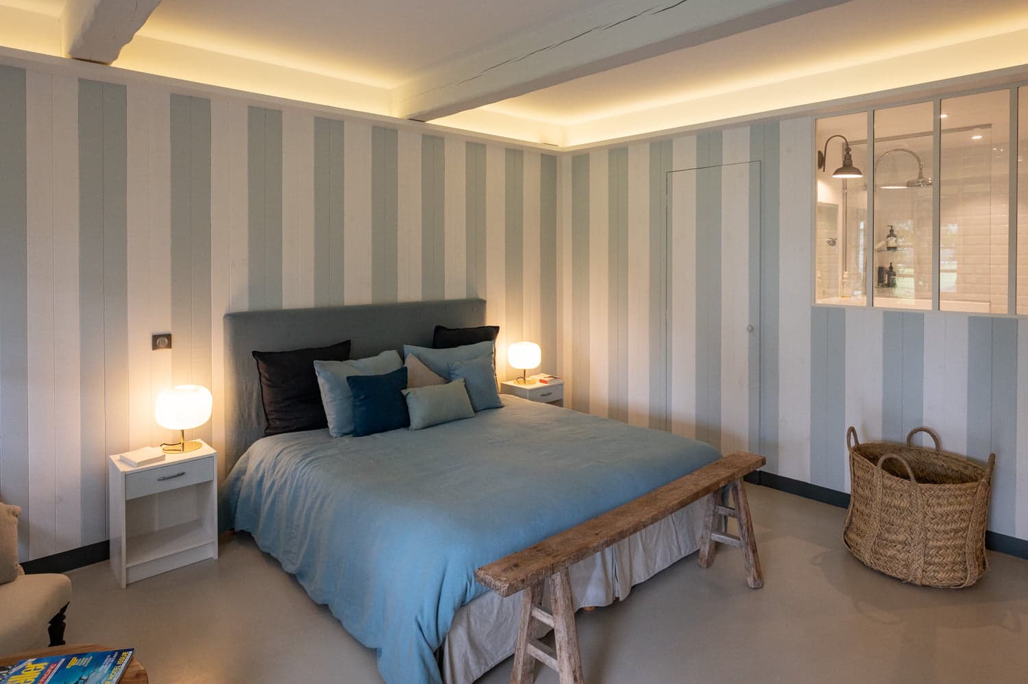 Lit double dans la chambre aux murs rayés bleus du Mas des Amis