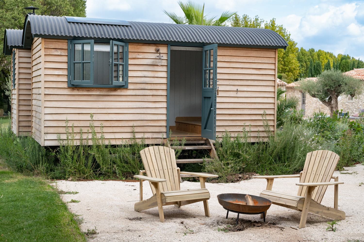 Chaises longues et brasero devant la roulotte du jardin