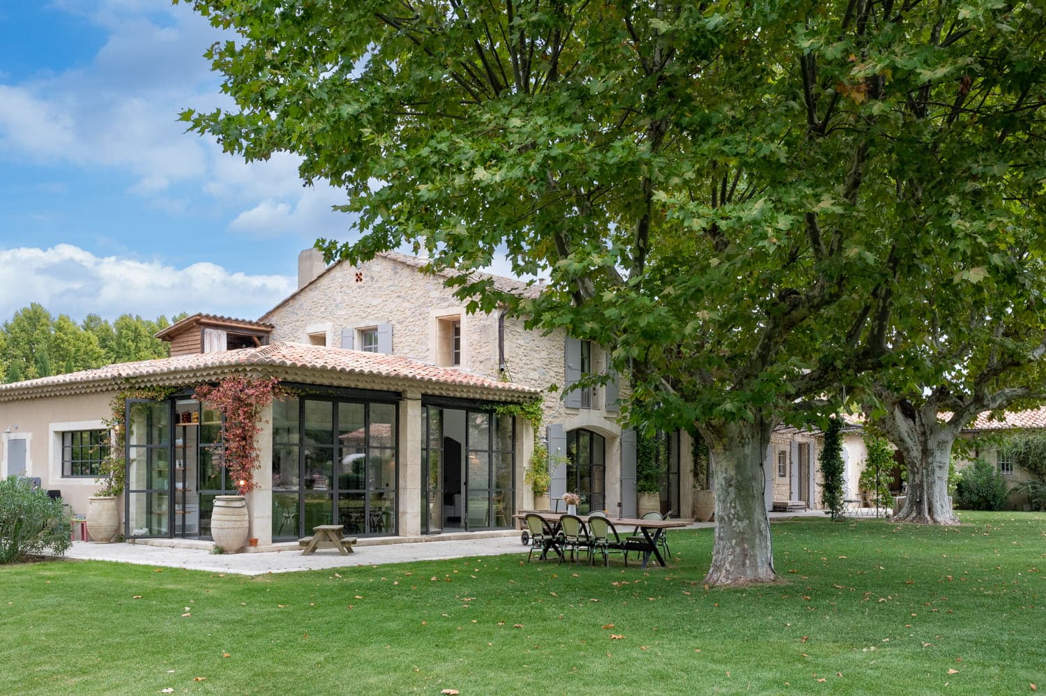 Jardin et baies vitrées de la maison en pierre