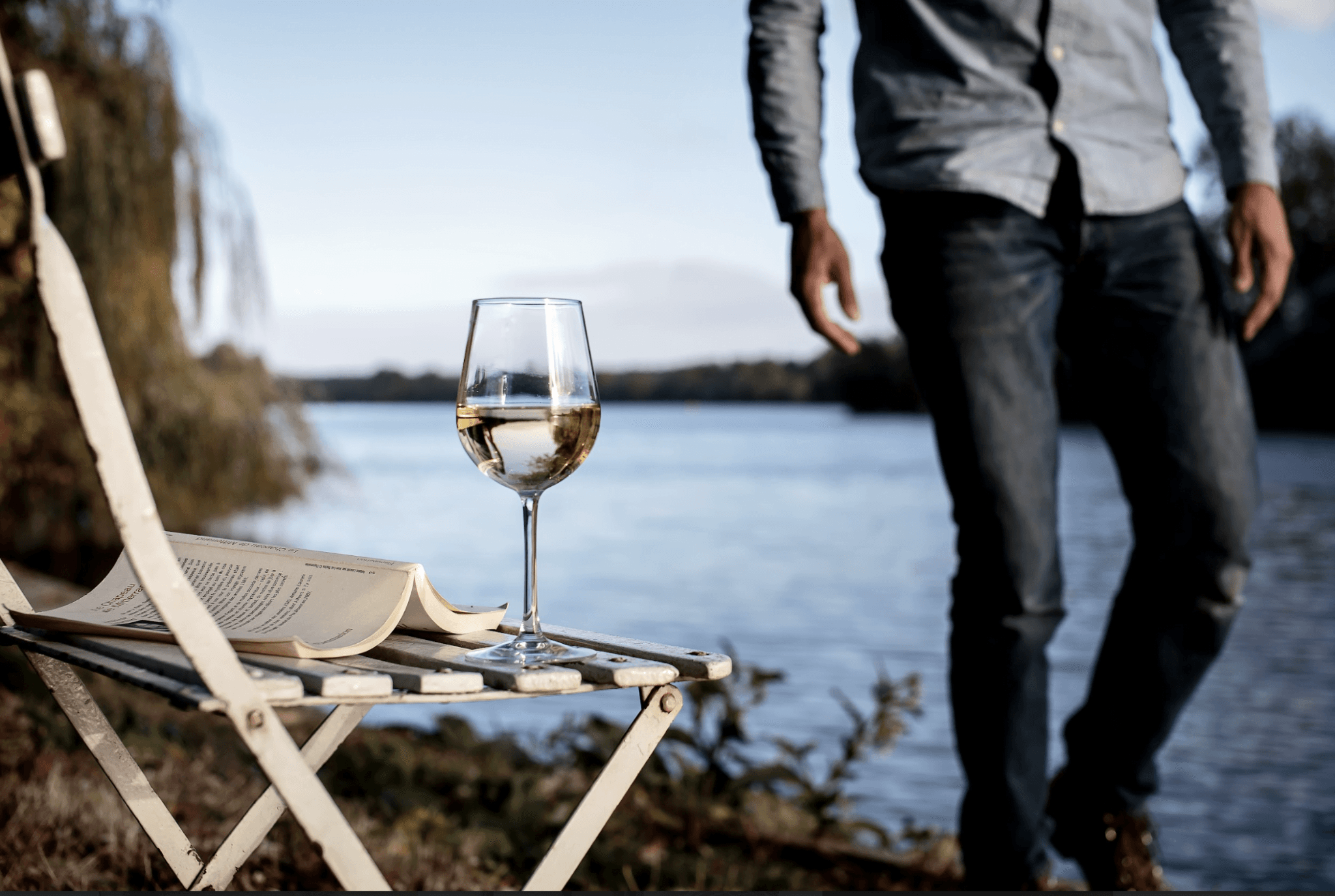 Verre de vin blanc et livre au bord de la Seine