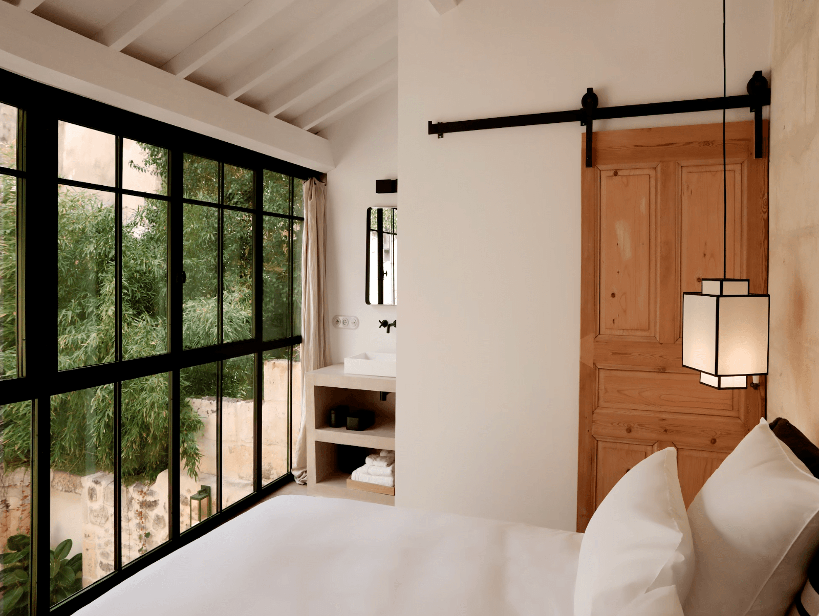 The sleek bedroom overlooking the pool and terrace