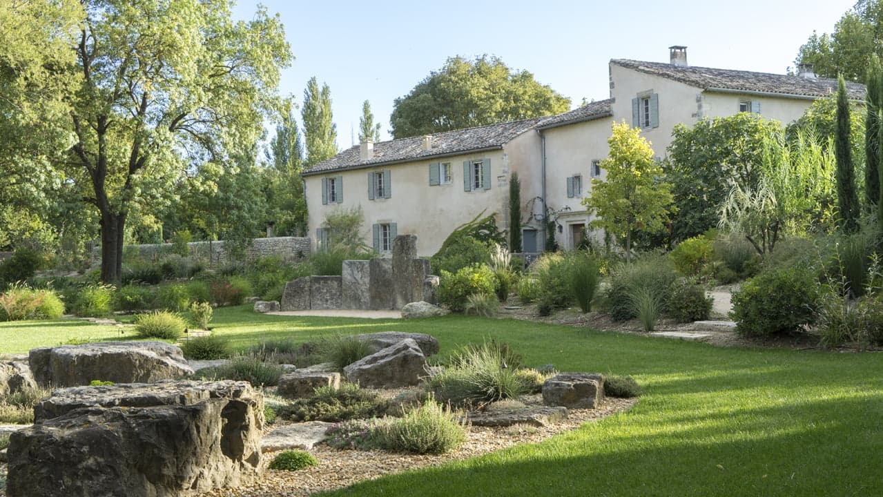 La vue depuis le jardin du Mas le Gaudre : pierres, pelouse et arbres