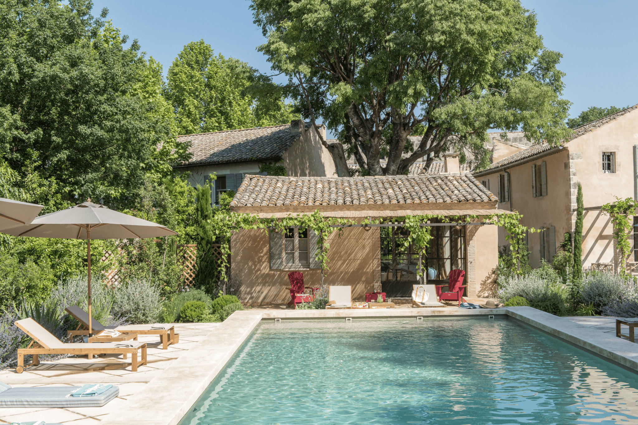 La piscine du Mas le Gaudre : pierre claire, petite maison de thé et transats