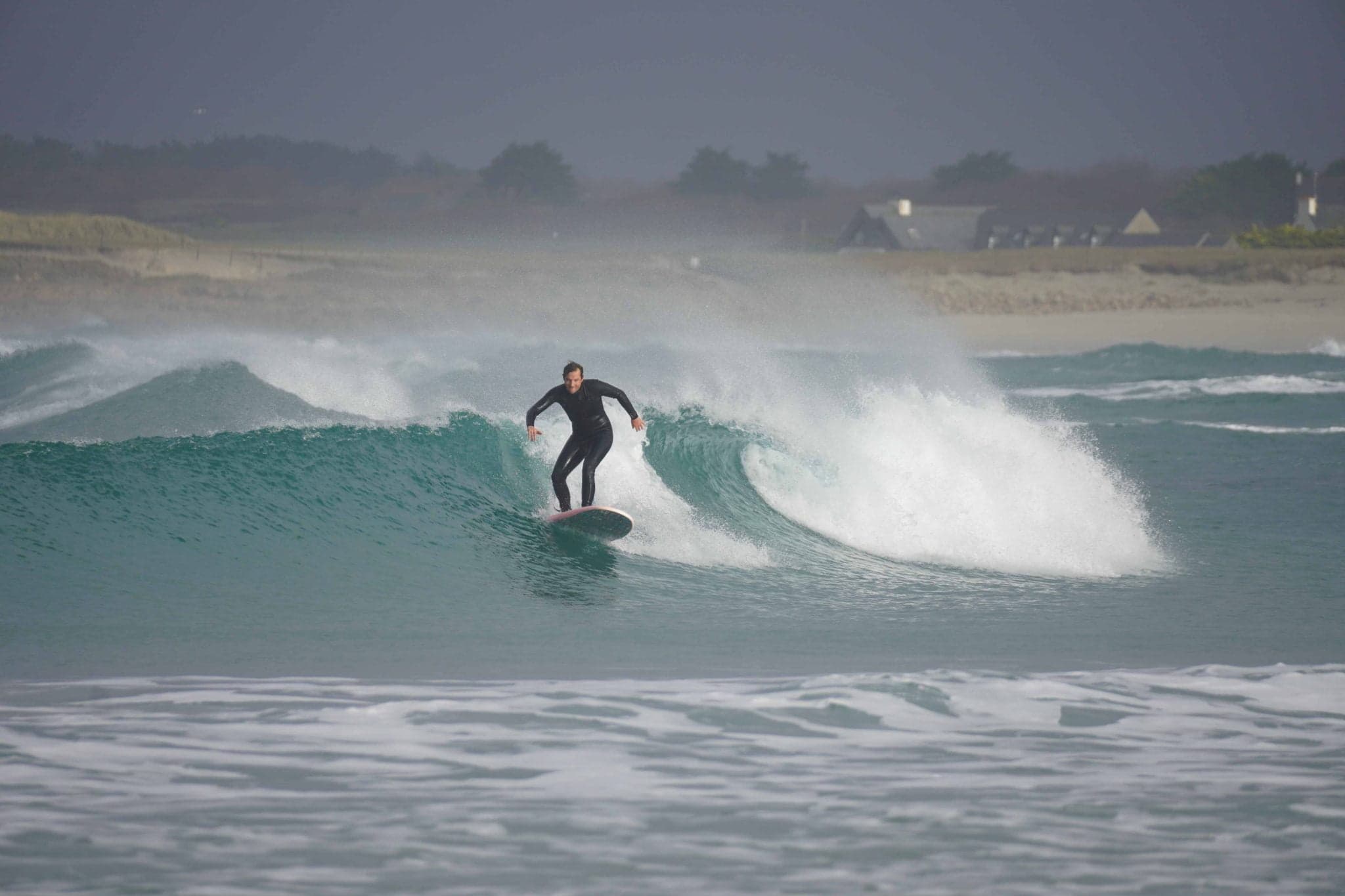 Un surfeur debout sur sa planche dans les vagues