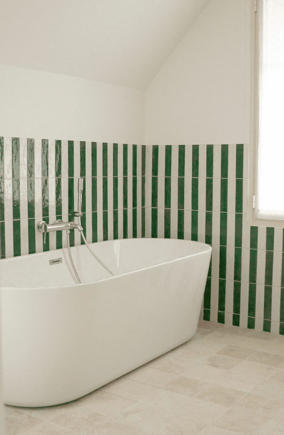 La baignoire blanche de la salle de bain, mur à rayures