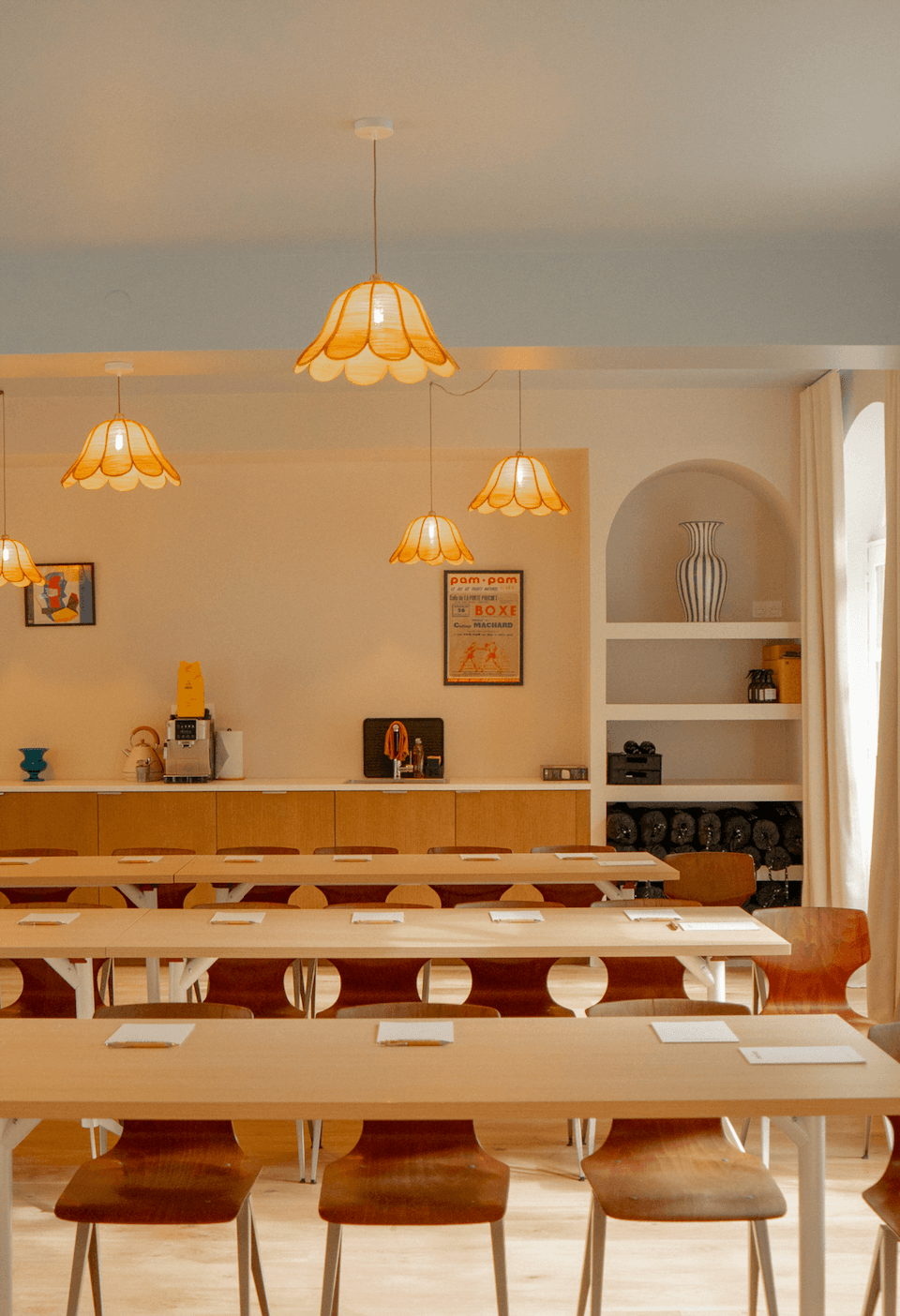 The dining room of La Source: wooden tables and chairs, suspended lights