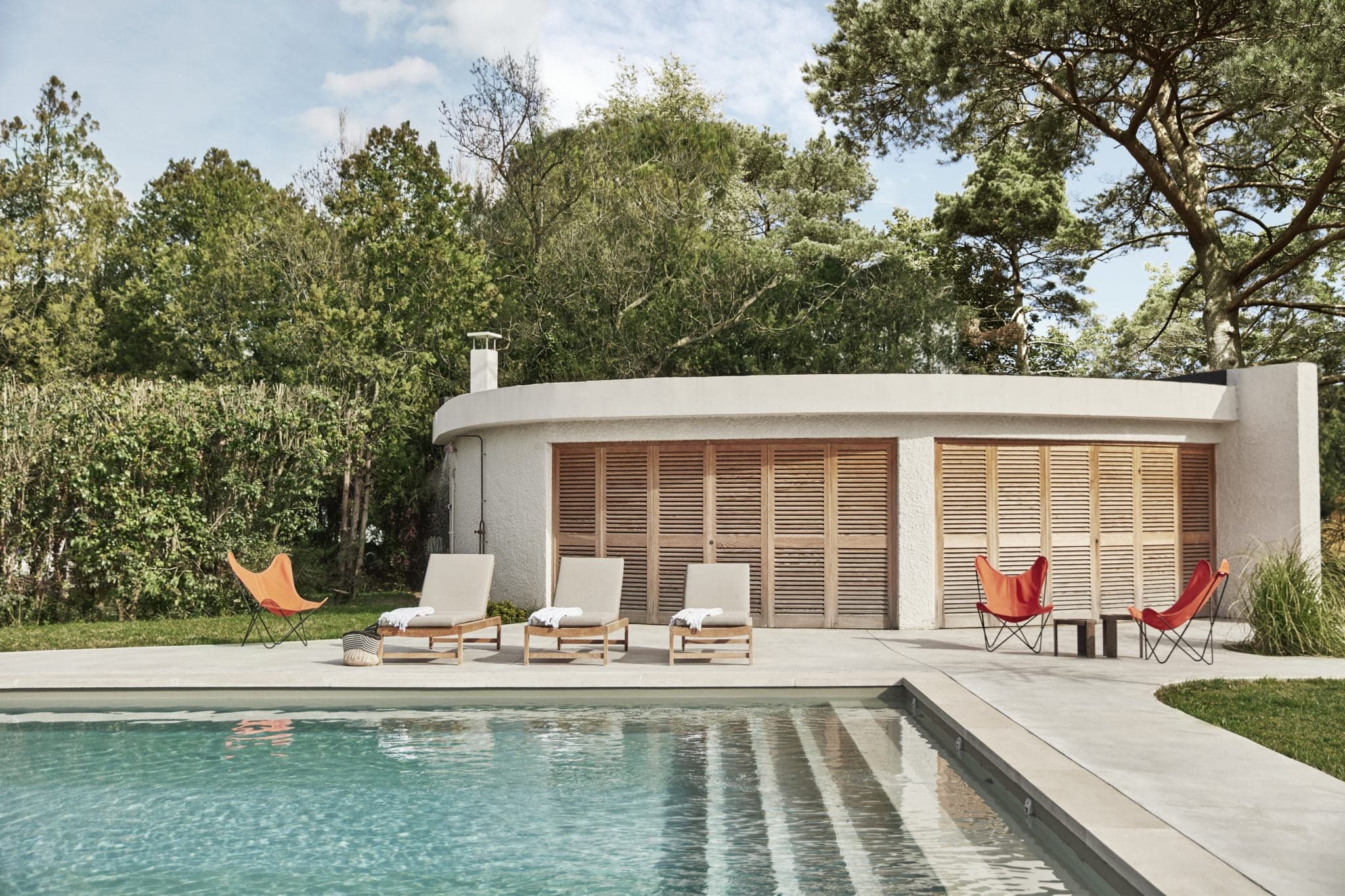 Les transats et la pool house autour de la piscine