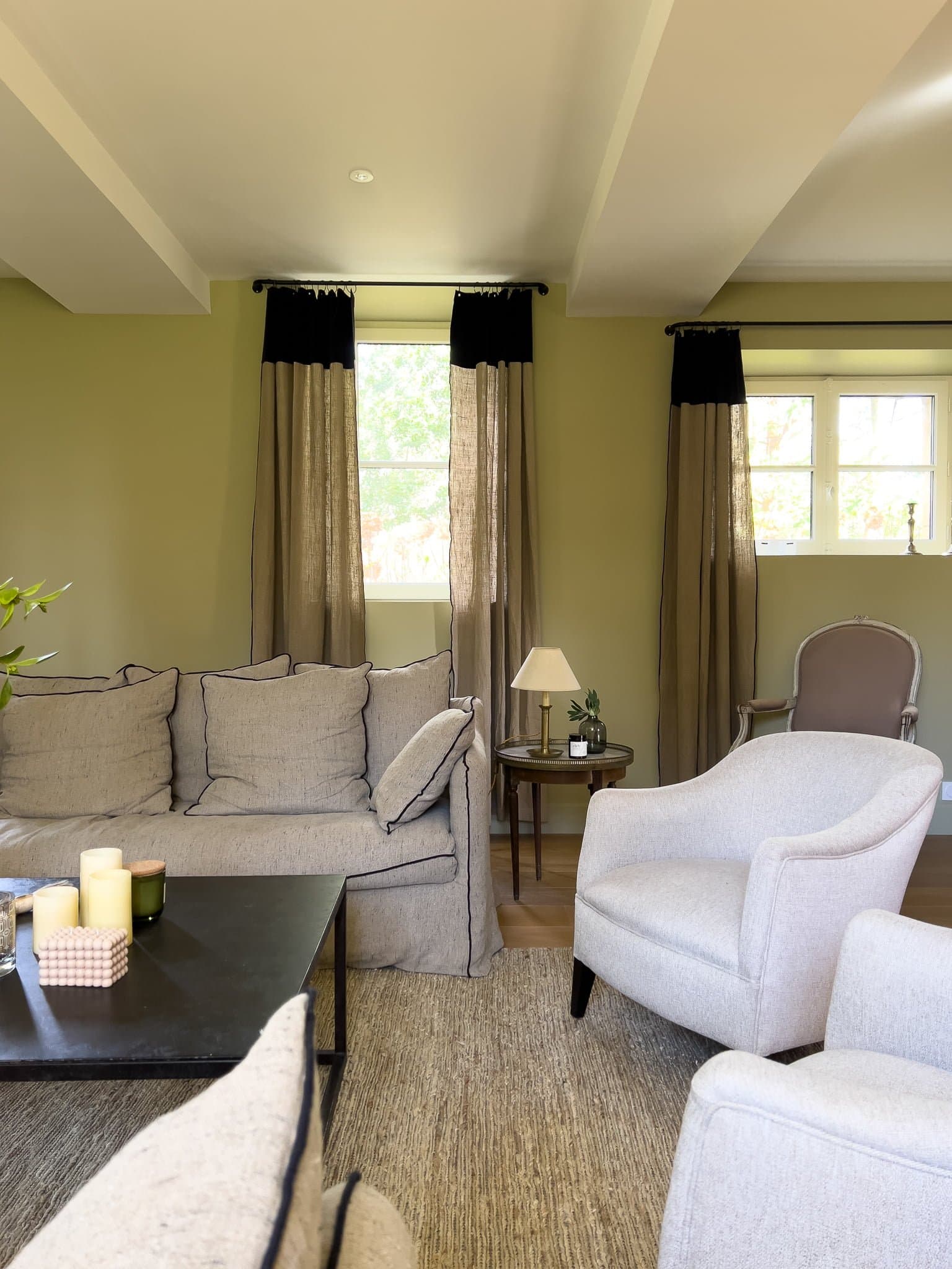 L'un des salons du château, canapé gris, fauteuils blancs