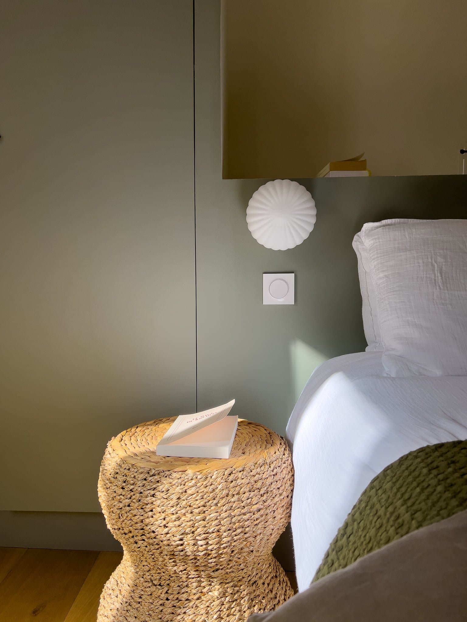 Détail de l'une des chambres : table de nuit en rotin