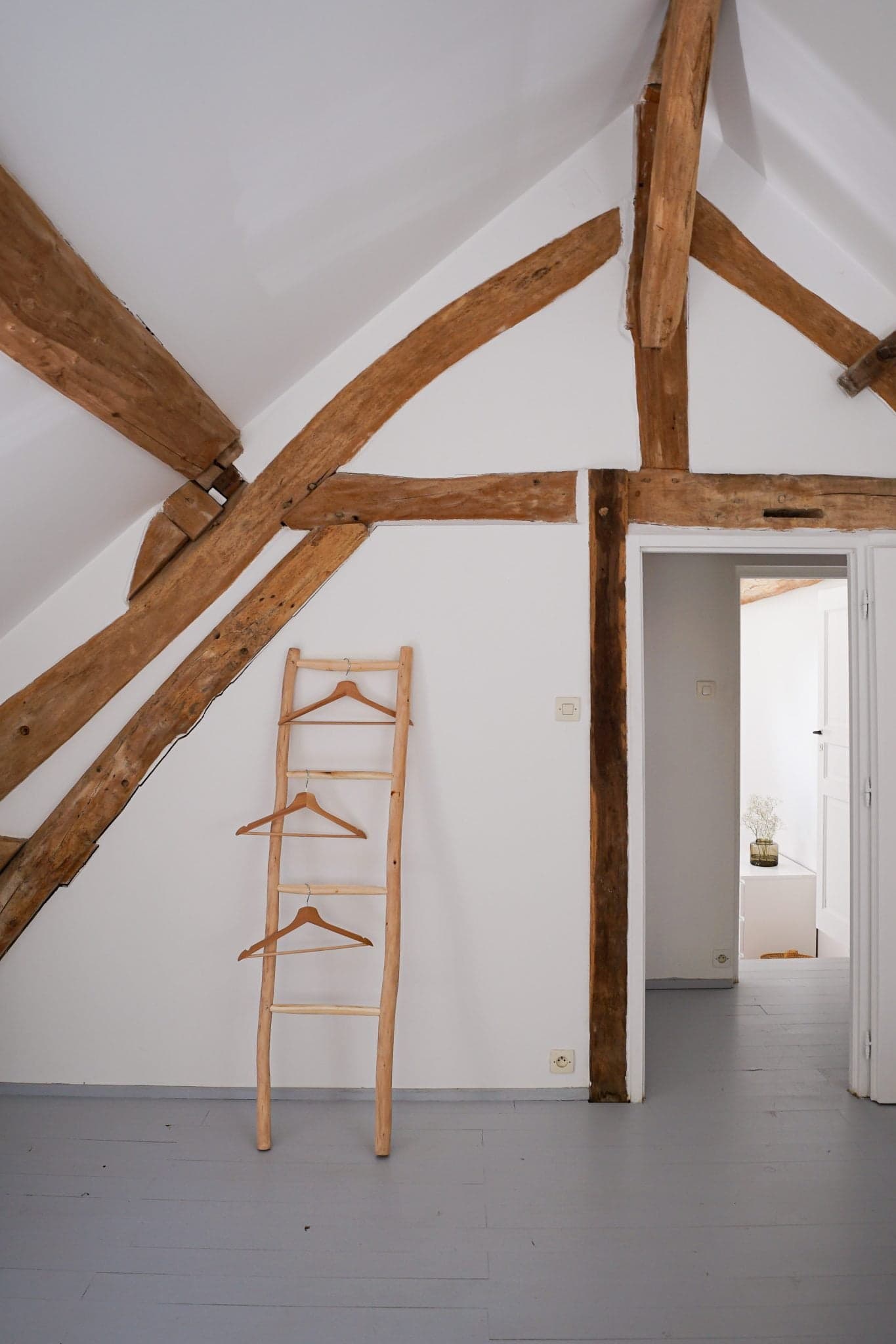 Porte-serviette en bois contre un mur blanc, poutres en bois