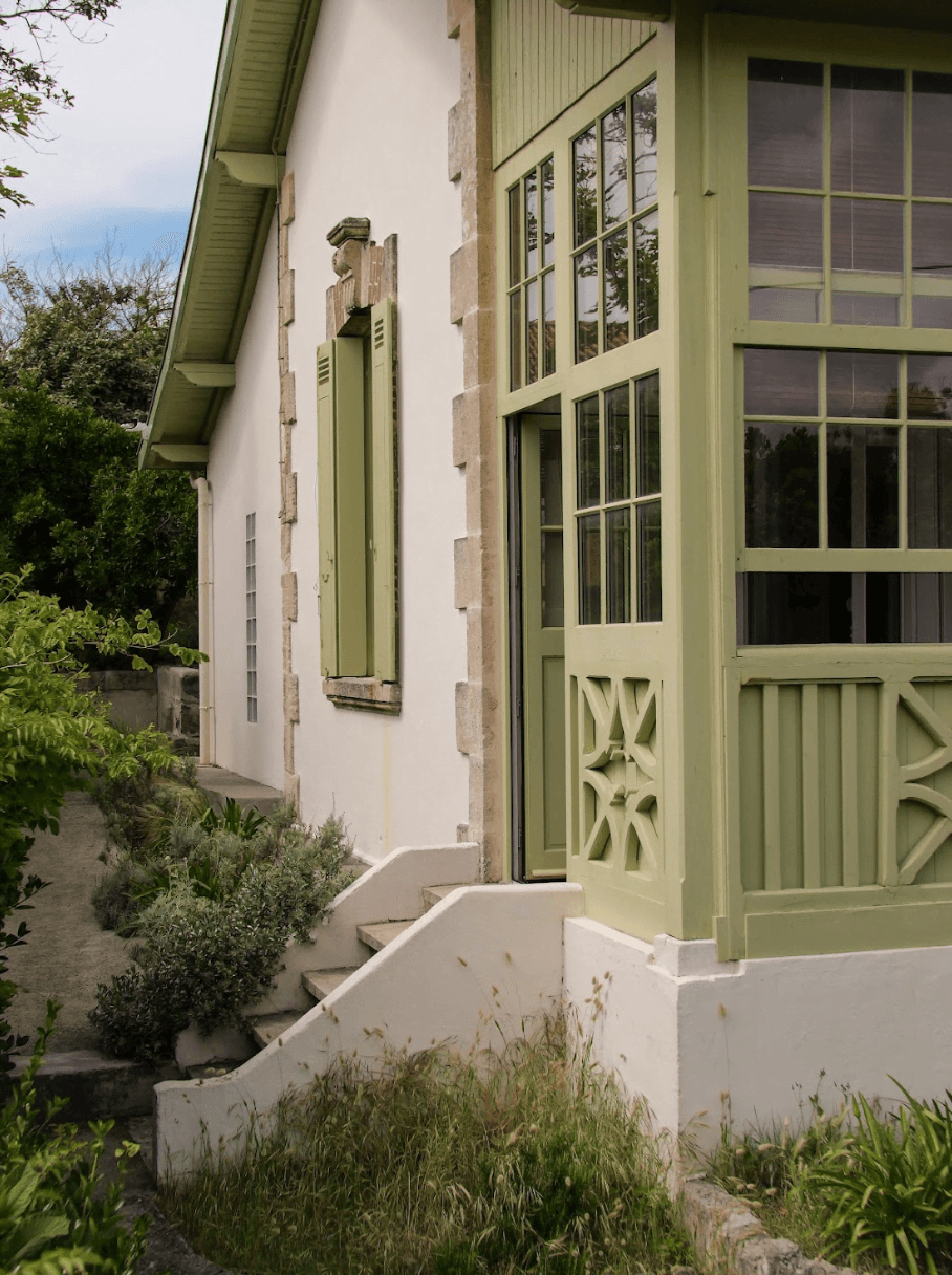 The entrance of the villa, mint green woodwork, small stone staircase