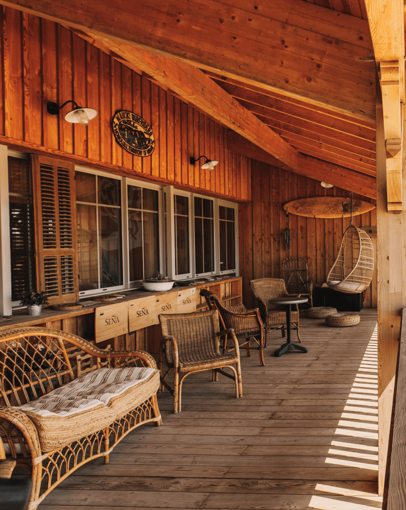 Terrasse en bois, fauteuils en rotin, baie vitrée