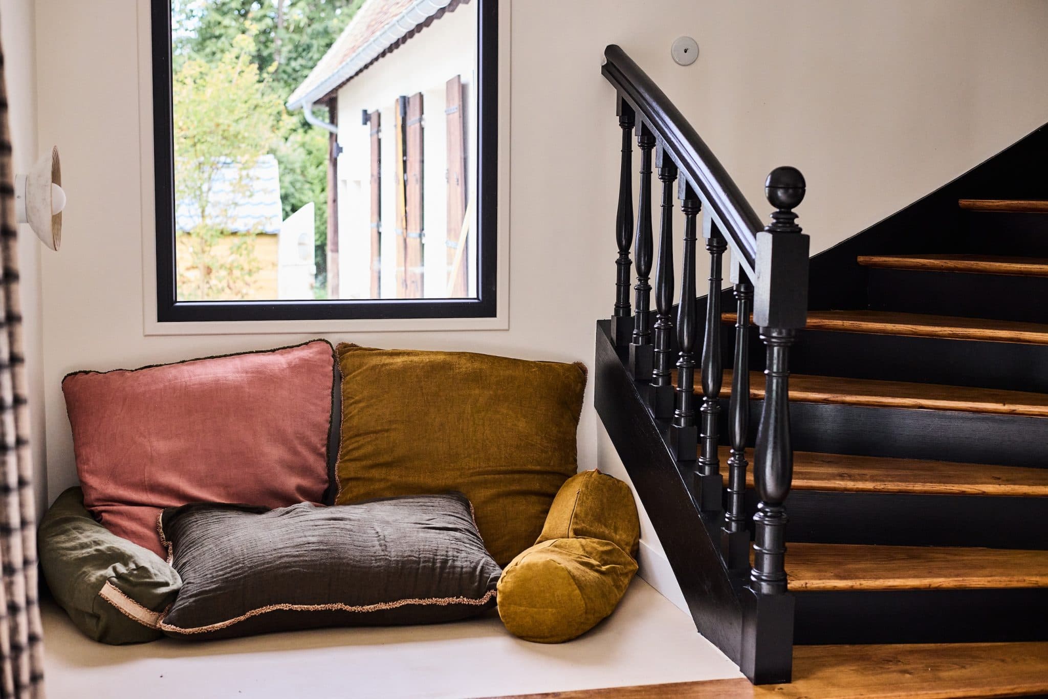 Next to the staircase, a reading nook (or nap spot).