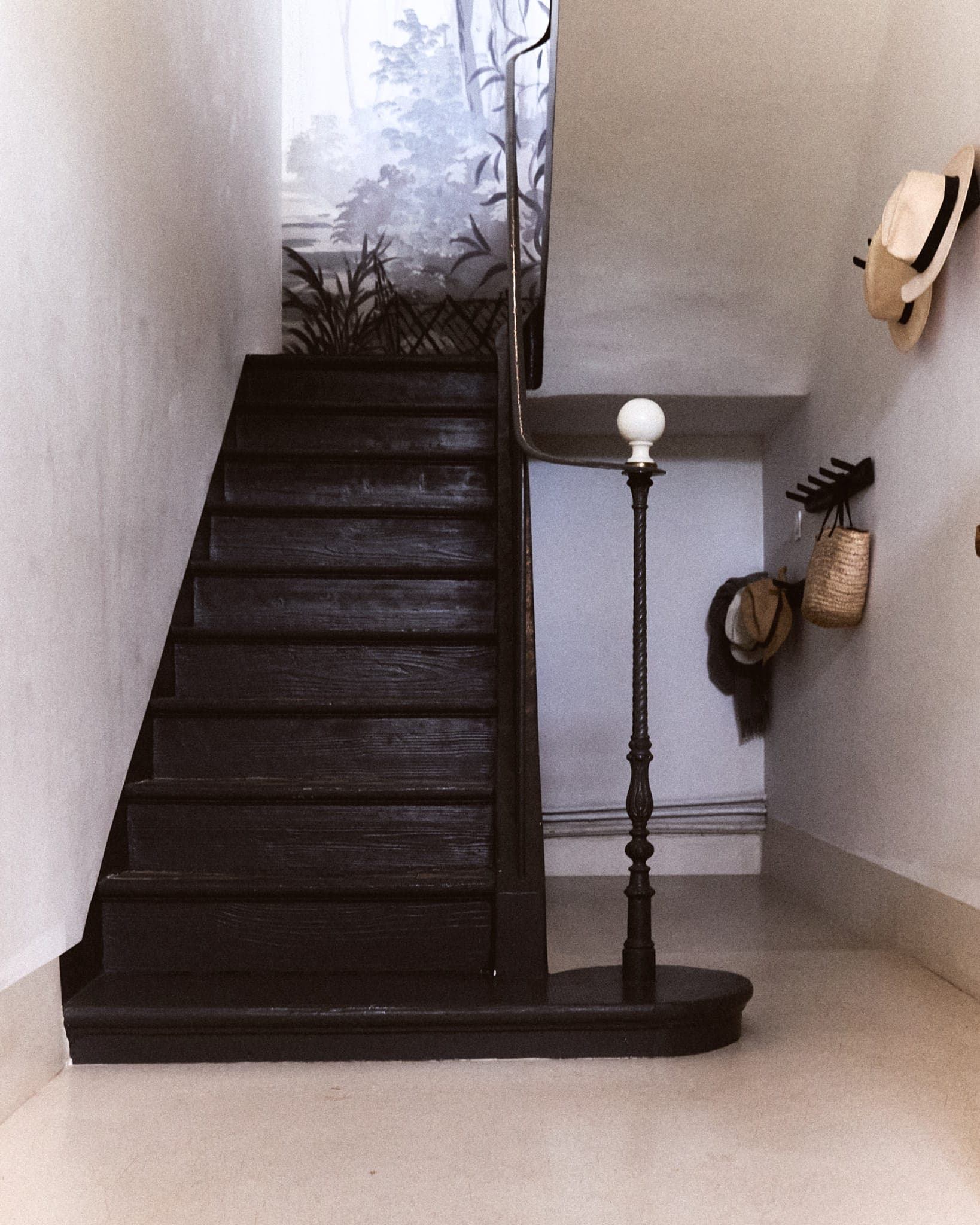Harmonie entre l'escalier en bois sombre et les murs clairs peints à la chaux. 
