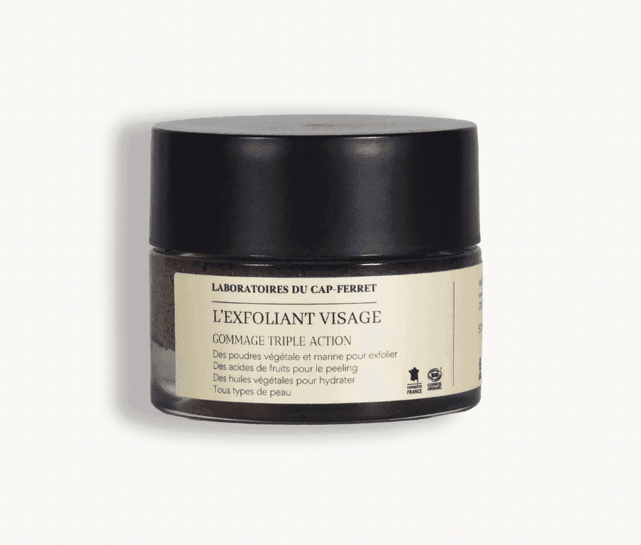 Un pot rond étiqueté « L'Exfoliant Visage », des Laboratoires du Cap-Ferret. Son étiquette couleur crème détaille le produit en français. Le pot est doté d'un couvercle foncé et cet exfoliant est conçu pour tous les types de peau.