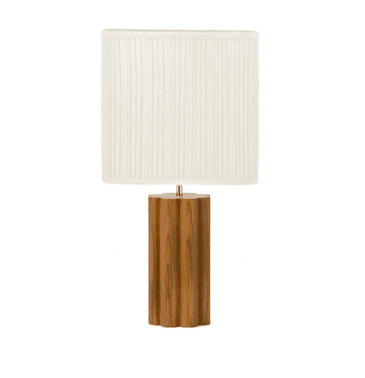 Lampe de table avec une base cylindrique en bois et un abat-jour en tissu plissé blanc. La base en bois a une finition naturelle avec des veines de bois visibles. La lampe a un design simple et élégant.